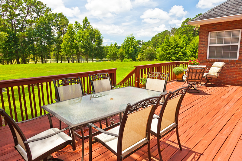 Large wooden backyard deck with outdoor furniture   during while re-inspection services are being preformed